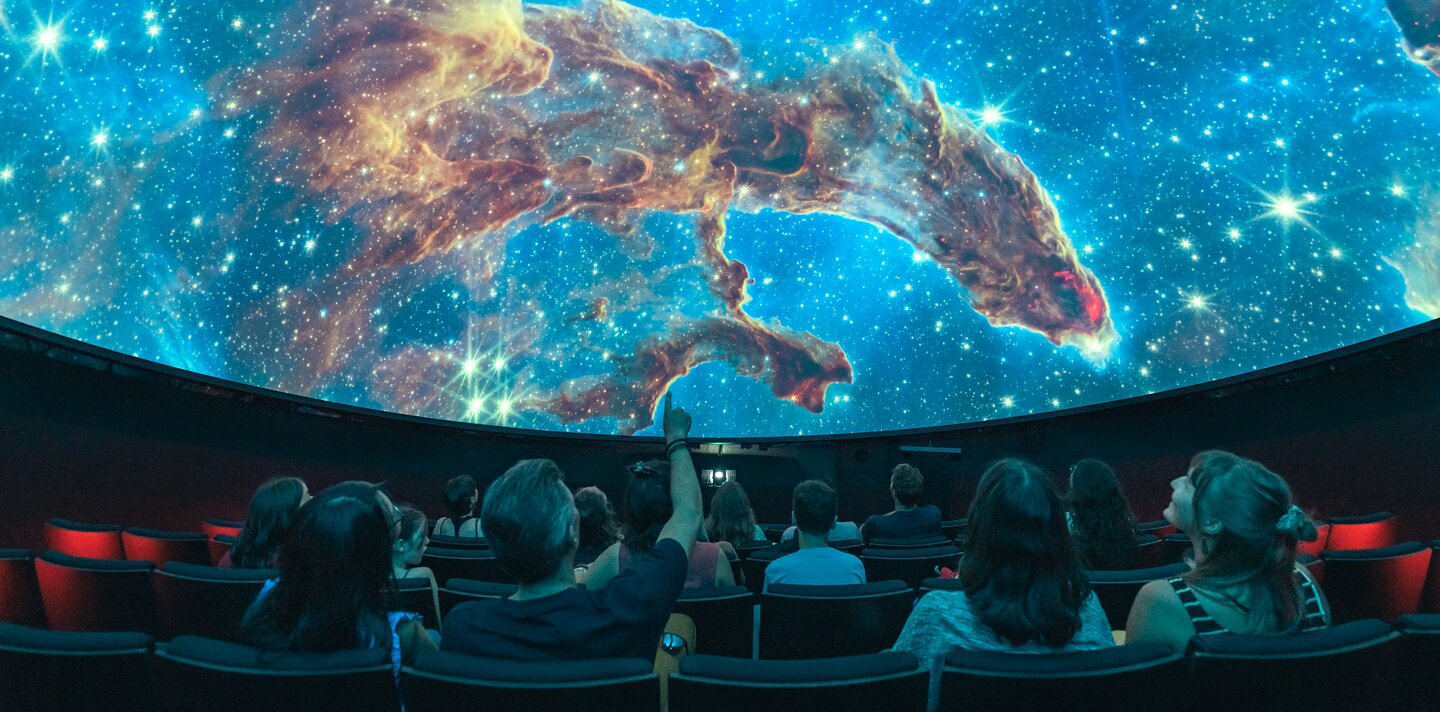 Menschen im Planetarium erleben eine Show, wie es auch im Space Eye auf der Uecht möglich ist.