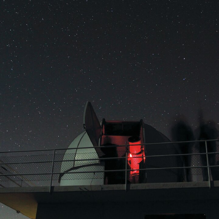 Blick auf die historische Schaerer-Sternwarte und ihr Teleskop bei Nacht, direkt neben dem Space Eye
