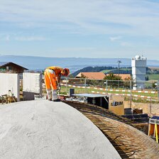 Bauarbeiter:in auf der Kuppel des Space Eye Planetariums mit dem Sonnenturm im Hintergrund | © Dirk Weiss